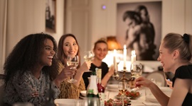 豪華なディナーテーブルでワインを飲みながら交流する美しい外国人女性たちの写真