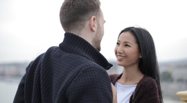 外国人男性とアジア人女性が幸せそうに目を見つめ合っている写真