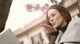ビデオ通話中の相手にキスを送る美しい女性の写真