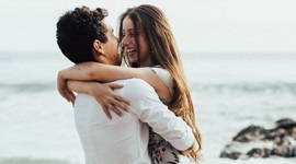 ビーチで女性を抱きかかえている男性の写真