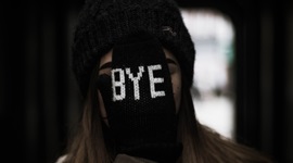 手袋をはめた手で顔を覆っている女性の写真