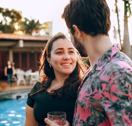 男性とラテン系女性がお酒を飲みながら楽しく会話を楽しんでいる写真